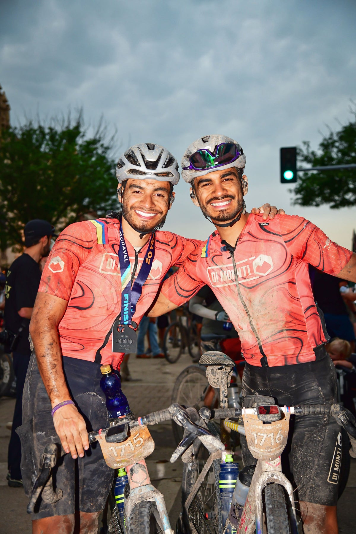 Dos ciclistas de Di Monti cubiertos de barro con su medalla de finalistas de Unbound 200