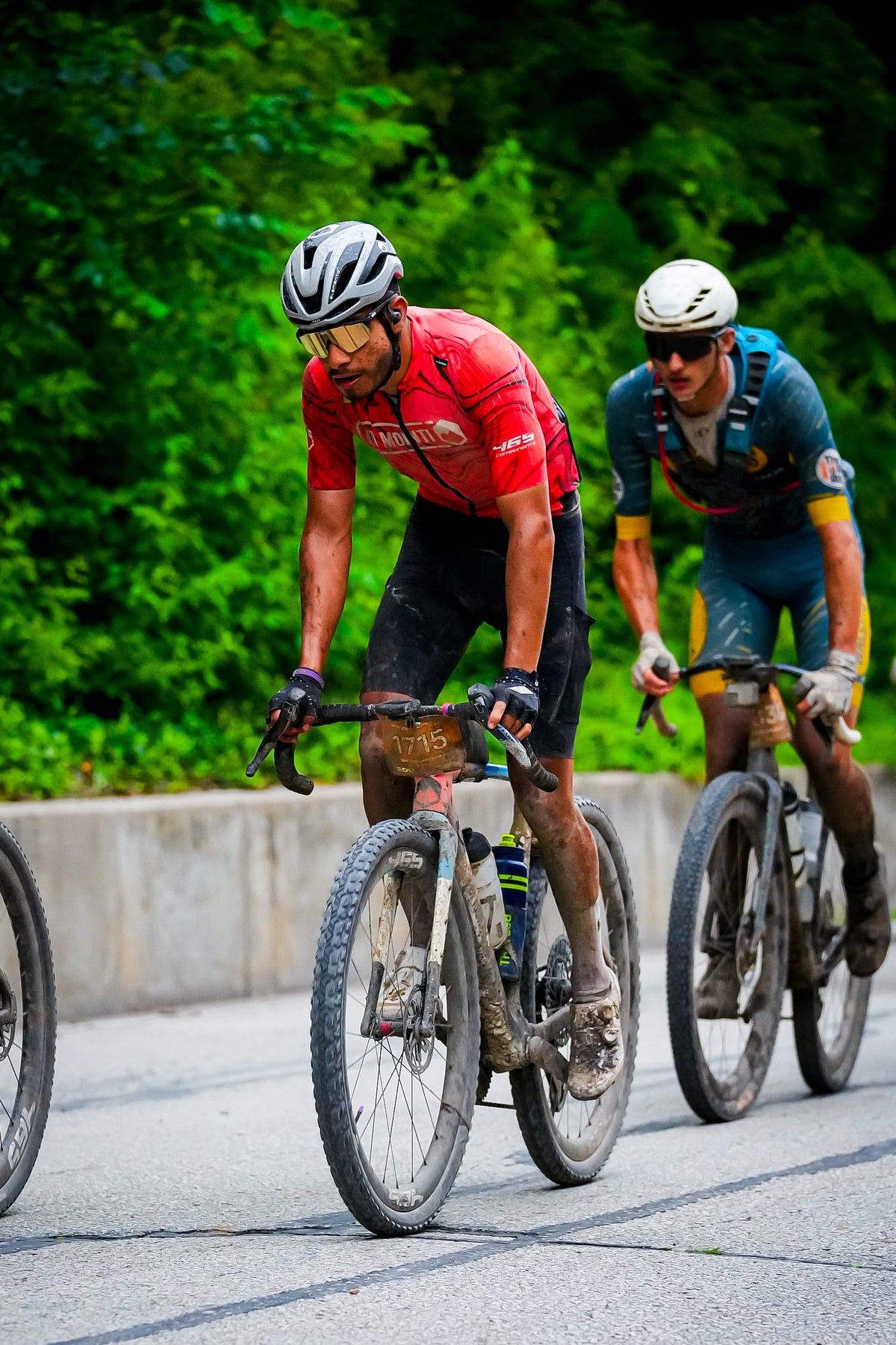 Ciclista de Di Monti con dorsal 1715 en carrera, cubierto de barro, en Unbound 2026