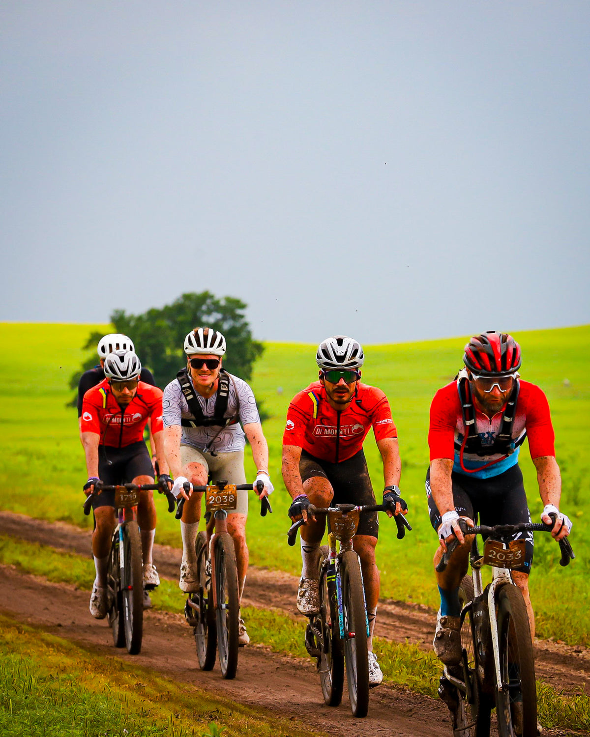 Grupo de ciclistas con el equipo Di Monti en un camino embarrado de Unbound 2026